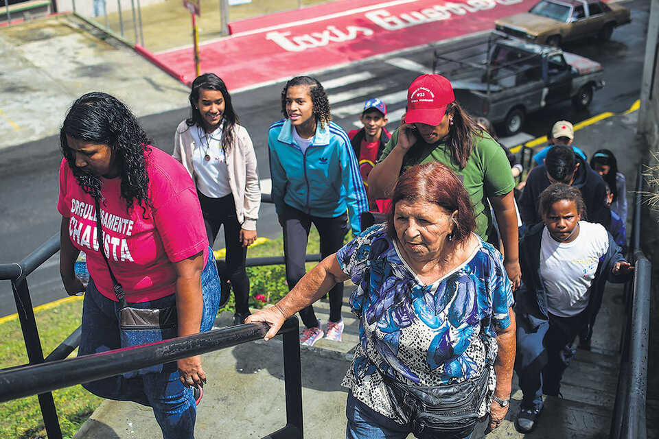 Mujeres venezolanas se dirigen a un centro de votación para elegir constituyentes en el emblemático barrio popular 23 de Enero de Caracas (Fuente: AFP)