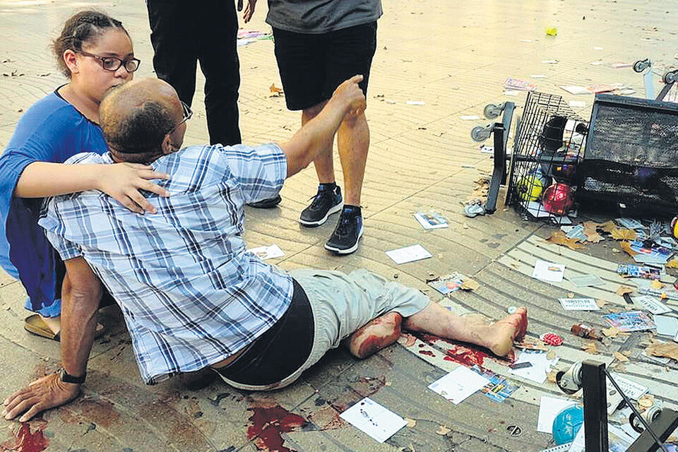 Una mujer asiste a un herido en La Rambla de Barcelona después del ataque reivindicado por el Estado Islámico.