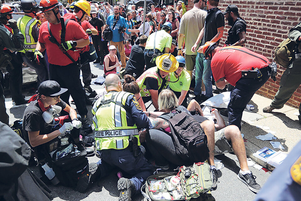Paramédicos atienden a los heridos después de que un auto embistiera contra la multitud.