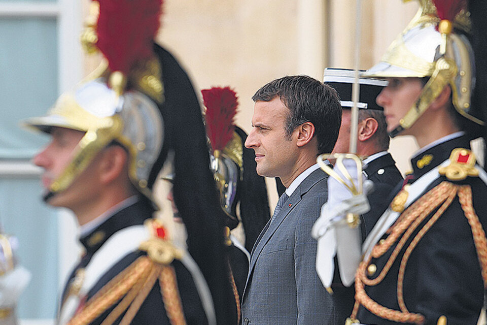 Macron rodeado de guardias ceremoniales durante un acto en el Elíseo.