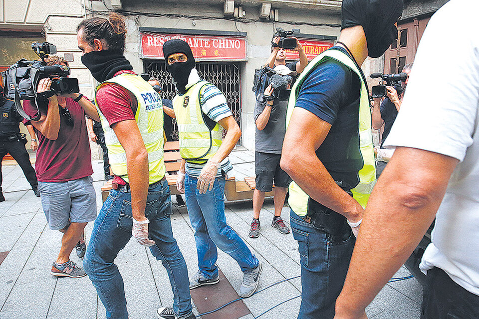 Policías catalanes salen de un edificio en Ripoll después de un allanamiento por los atentados del jueves. (Fuente: AFP)