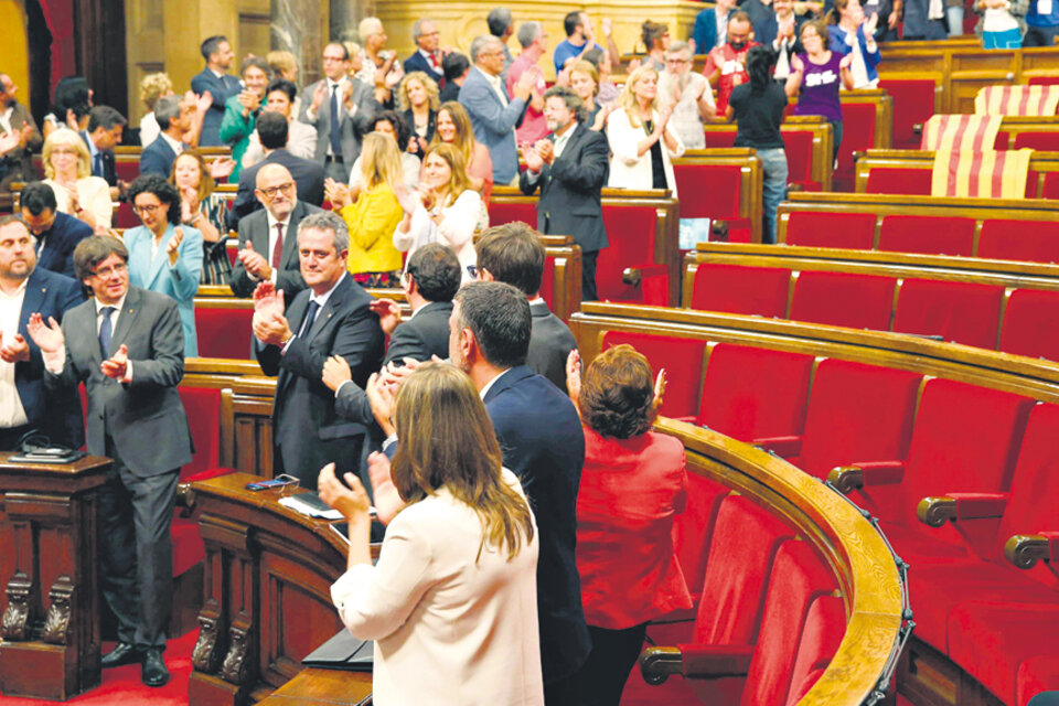 Puigdemont (segundo, abajo) y miembros de su gobierno festejan la votación en el Parlamento catalán. (Fuente: EFE)