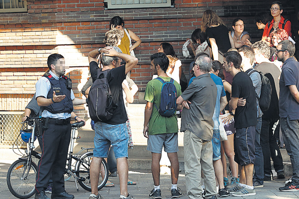Vecinos ocupando la Escola Collaso i Gil conversan con un Mosso d’Esquadra horas antes del referéndum. (Fuente: AFP)