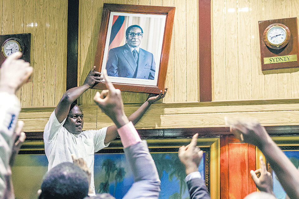 Retiran el retrato de Mugabe en el Parlamento después del anuncio de su renuncia. (Fuente: AFP)