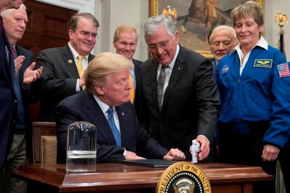 Fly Me To The Moon: un astronauta de juguete en el escritorio, mientras Trump firma la directiva. (Fuente: EFE)