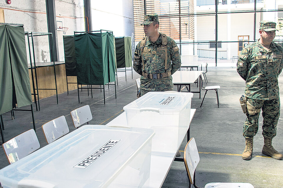 Soldados chilenos vigilan las urnas en un centro de votación ubicado en un colegio secundario de la capital chilena. (Fuente: AFP)