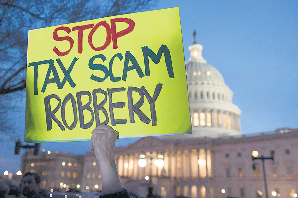 “Paren la estafa del robo de impuestos”, dice el cartel de un manifestante frente al Capitolio. (Fuente: AFP)