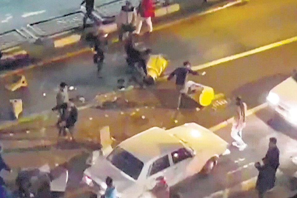 Un grupo de manifestantes patea barreras de tránsito el sábado a la noche en una calle de Teherán.