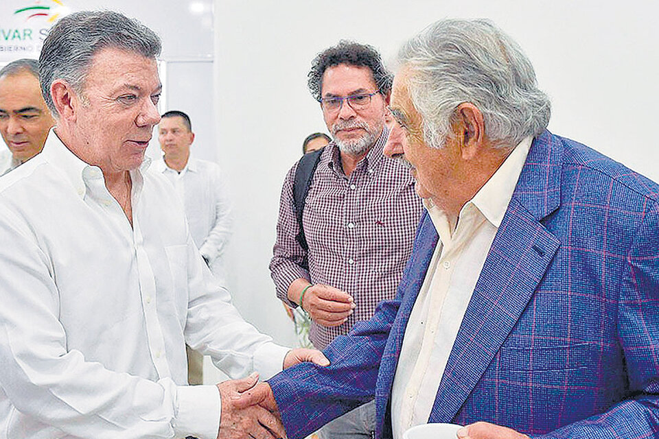 Santos saluda a Mujica en presencia de Pastor Alape, uno de los líderes de la ex guerrilla.