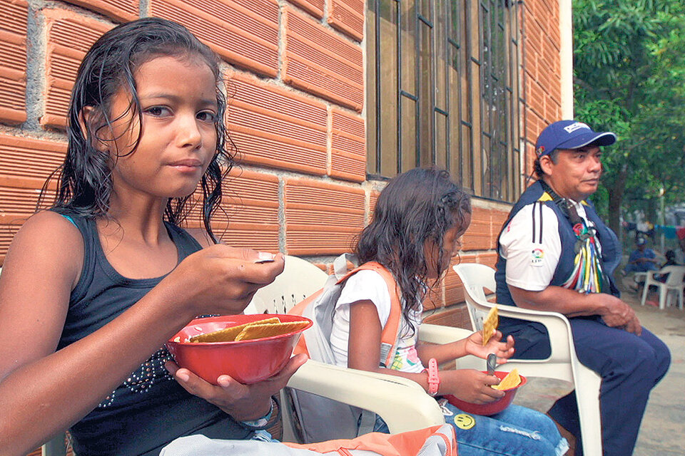 Dos niñas de una familia desplazada se alimentan en la Casa Indígena de Cáceres, un pueblo de Antioquía.