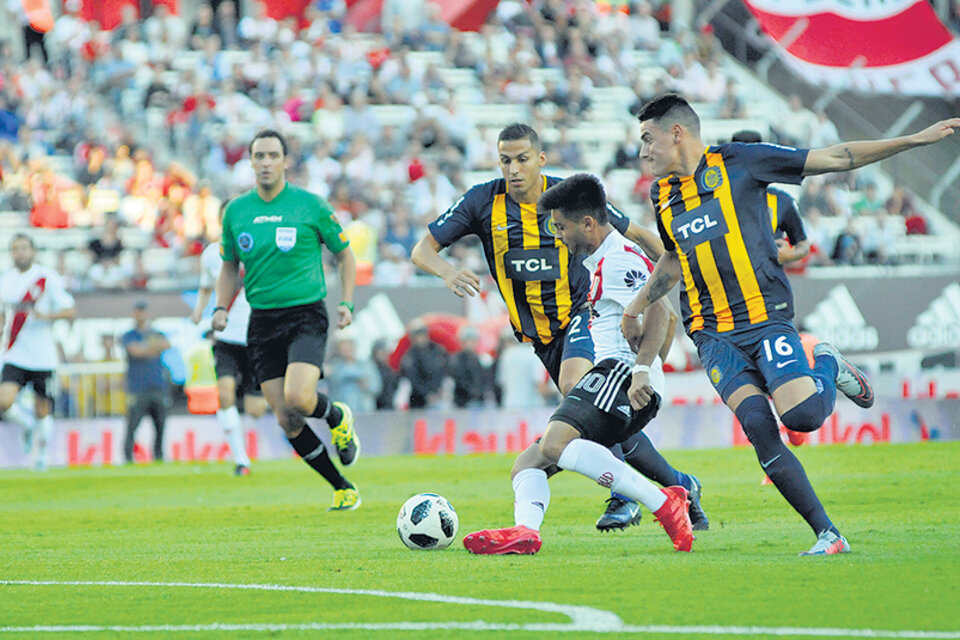 Gonzalo Martínez engancha ante la marca de Mauricio Martínez y Tobio, durante el segundo tiempo. (Fuente: Julio Martín Mancini)