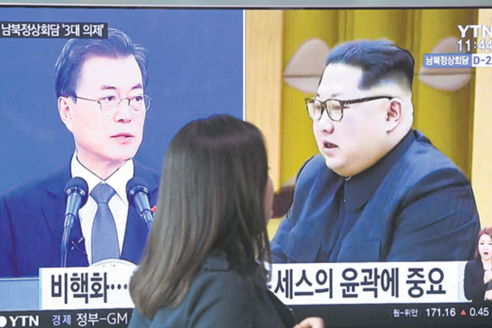 Moon y Kim aparecen en la pantalla de televisión ayer en una estación de subte de Seúl. (Fuente: AFP)