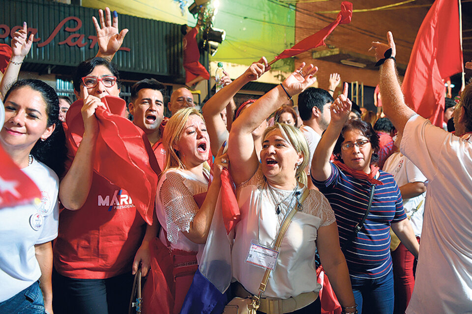 Simpatizantes del presidente electo Abdo Benítez festejan en el búnker de campaña del Partido Colorado en la capital paraguaya. (Fuente: AFP)