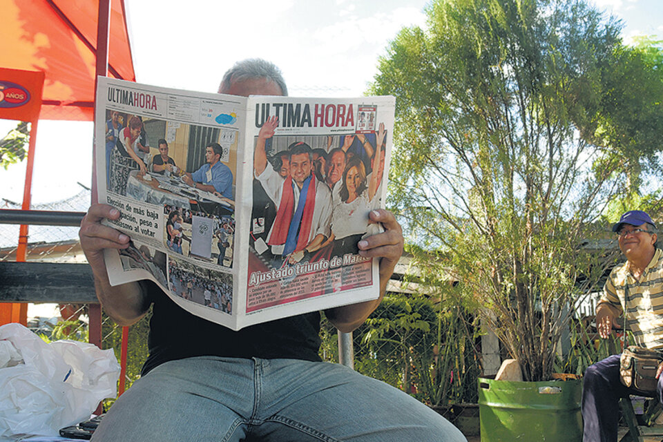 Un hombre lee el diario de ayer, en cuya tapa se destaca el triunfo de Mario Abdo Benítez. (Fuente: AFP)