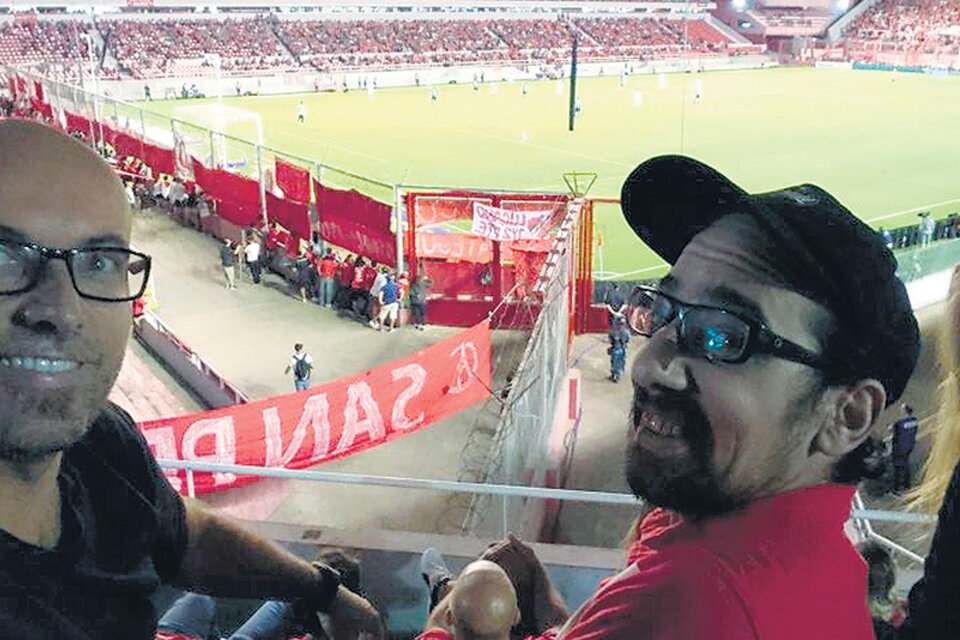 Francisco (con gorra) junto a su mejor amigo, Juan, en la platea del estadio.