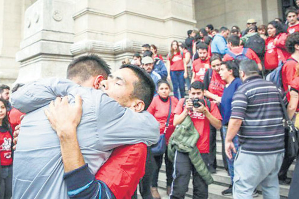 Jóvenes de La Poderosa abrazan a su fotógrafo, Roque Azcurraire, detenido ilegalmente. (Fuente: Gentileza La Garganta Poderosa)