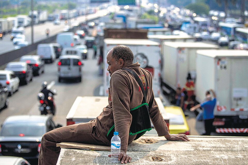 Un camionero observa el bloqueo de una autopista en la entrada a Río de Janeiro, donde ya se siente el desabastecimiento de insumos básicos. (Fuente: AFP)