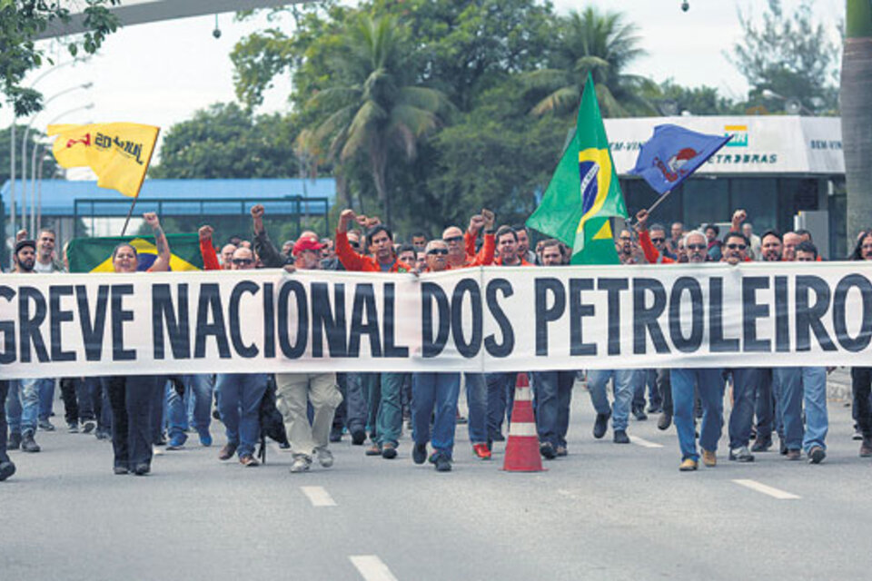 Trabajadores de Petrobras en Río sostenían una pancarta ayer anunciando la huelga nacional. (Fuente: AFP)