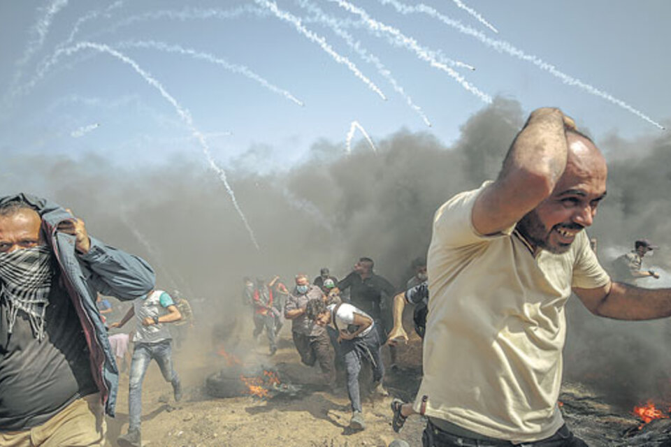 Palestinos escapan de ataques de gas lacrimógeno en la Franja de Gaza. (Fuente: AFP)