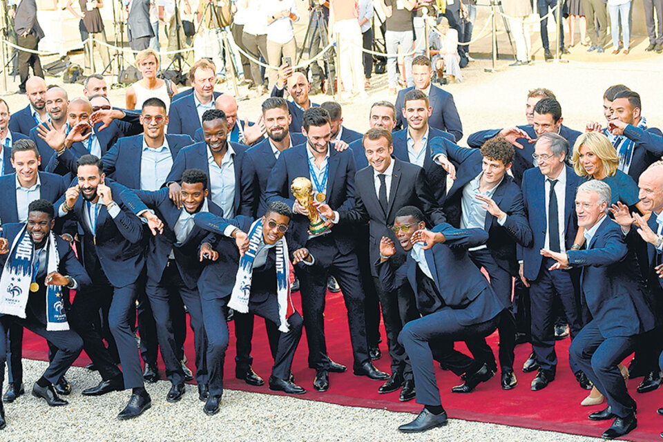 Los jugadores de Francia muestran la Copa y sus medallas junto al presidente Macron. (Fuente: AFP)