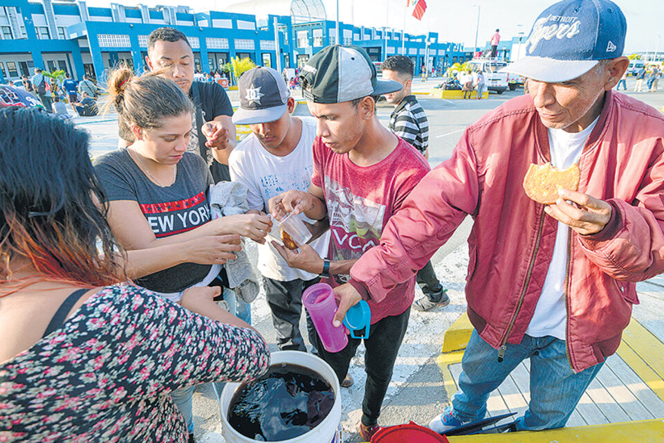 Inmigrantes venezolanos reciben comida en el Centro Binacional de Atención de Frontera de Huaquillas. (Fuente: AFP)