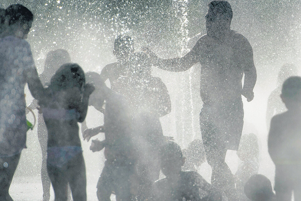 Chicos y grandes buscan un alivio en las fuentes de Madrid. (Fuente: AFP)