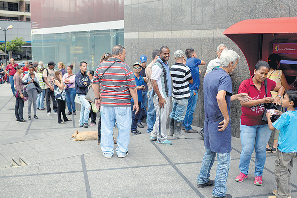 Venezolanos hacen cola en cajeros automáticos, donde pudieron sacar hasta 10 bolívares soberanos.