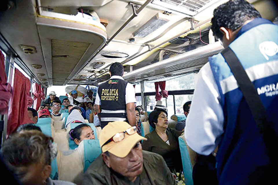 Agentes migratorios revisan documentos en un ómnibus en la localidad fronteriza de Tumbes. (Fuente: EFE)