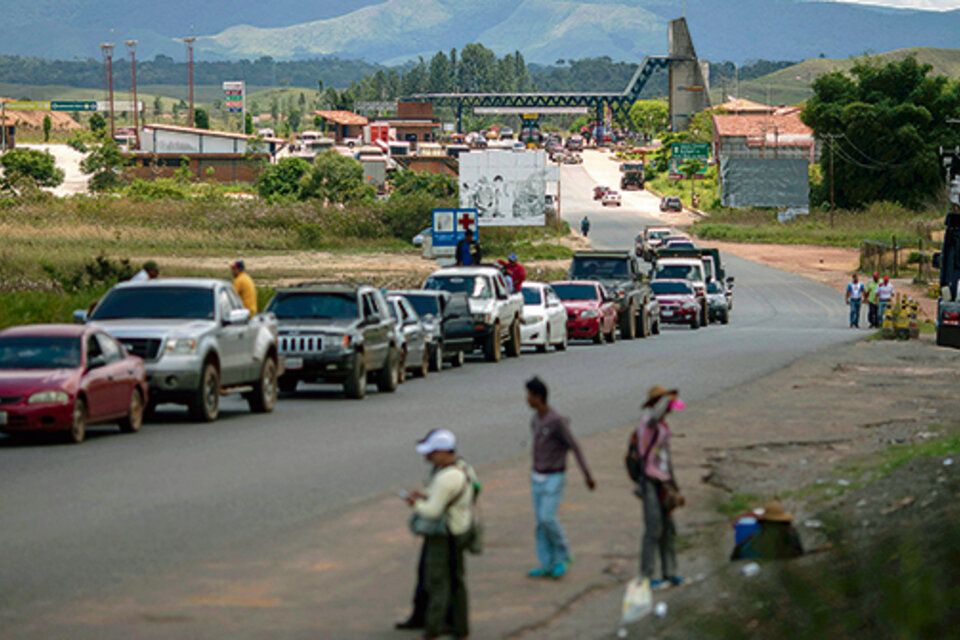 Una fila de autos espera en la entrada a Pacaraima, en el estado de Roraima, Brasil. (Fuente: AFP)