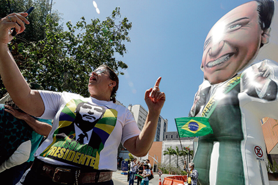 Simpatizantes de Bolsonaro instalan un muñeco inflable con la imagen del candidato en la puerta del hospital Albert Einstein. (Fuente: EFE)