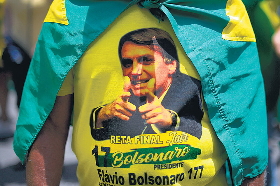 Un seguidor de Bolsonaro lleva una remera con la cara del candidato en uno de los actos se apoyo en Río. (Fuente: AFP)