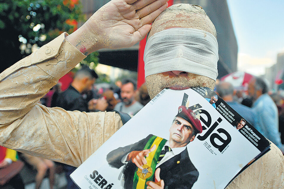 Un manifestante con los ojos vendados protesta en contra de Bolsonaro esta semana en San Pablo. (Fuente: AFP)