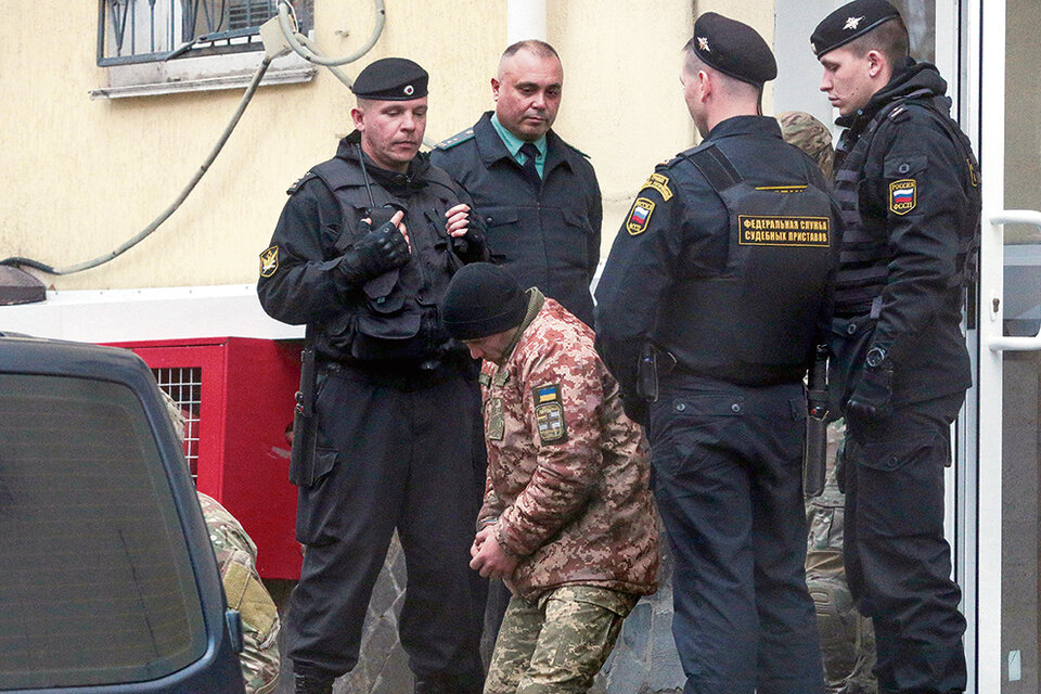 Un marino ucraniano es escoltado por militares rusos luego der ser detenido en Crimea.