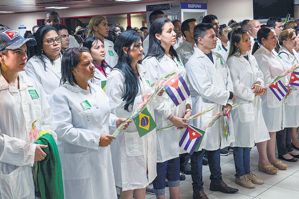 Con las banderas de las dos naciones, los médicos abandonan Brasil hacia Cuba.
