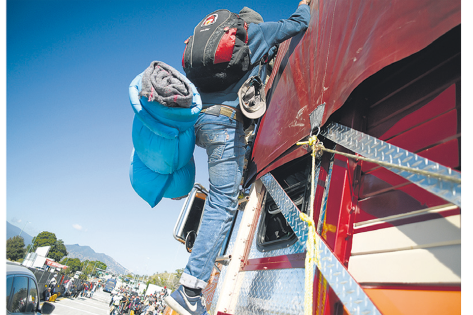 Un miembro de la caravana se sube a un camión en Jalisco.