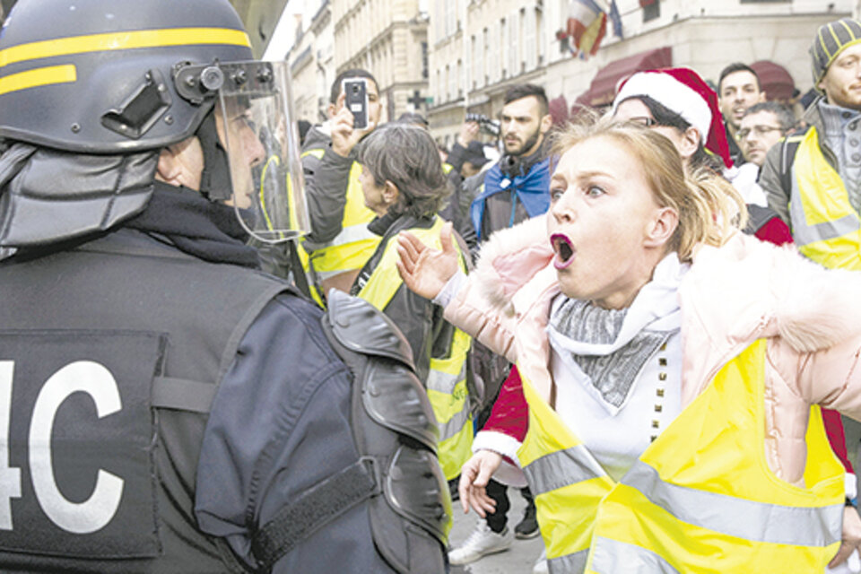 Una manifestante le gritaba a un policía durante la protesta de ayer en París.