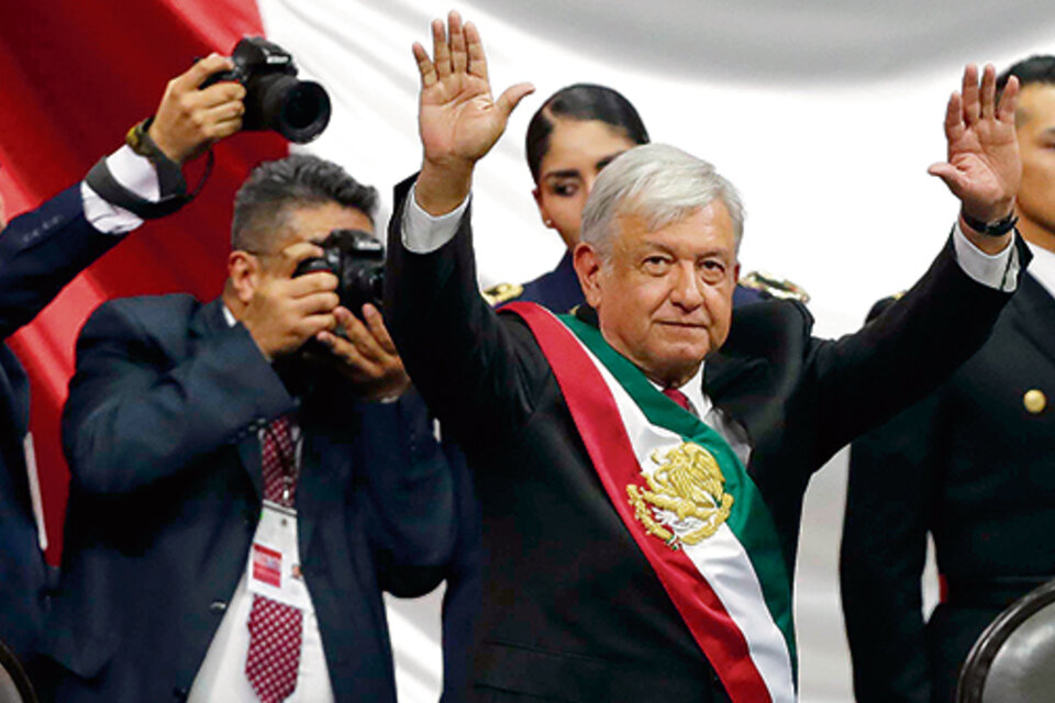 López Obrador saluda y festeja al término de su ceremonia de investidura en la Cámara de Diputados de la capital mexicana.