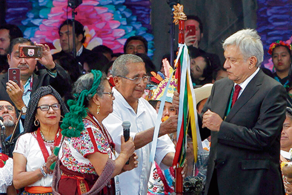 El presidente de México, Andrés López Obrador, recibe el bastón de Carmen Santiago.