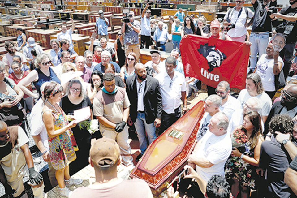 En el entierro de Vavá, un simpatizante de Lula sostiene una bandera del ex presidente.