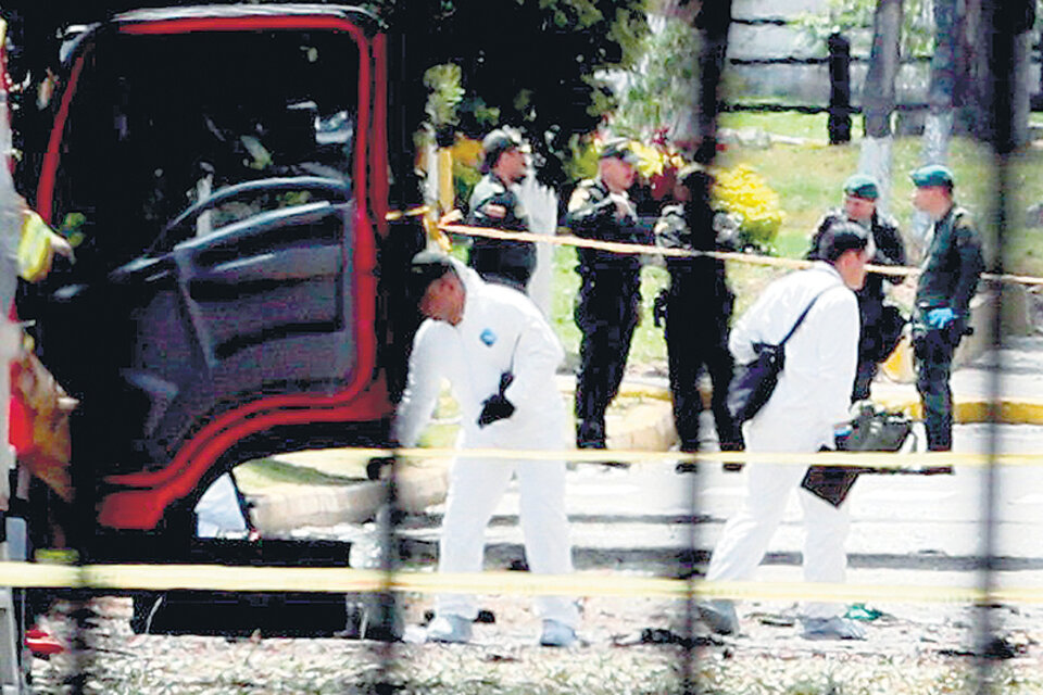 Expertos forenses trabajan en el lugar de la explosión en la academia policial General Santander de Bogotá.