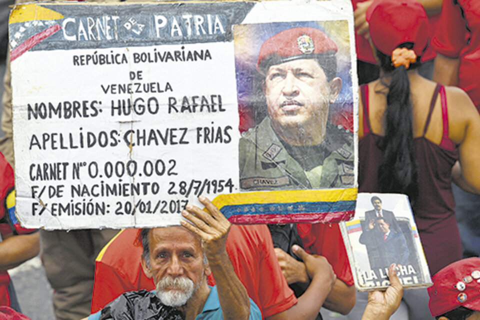 Simpatizantes chavistas muestran carteles del comandante fallecido en apoyo a Maduro en Caracas. (Fuente: AFP)
