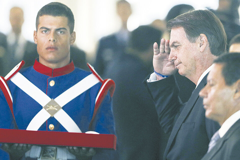 Bolsonaro se saludó con el vice Mourao, a su lado durante una ceremonia en Brasilia. (Fuente: AFP)
