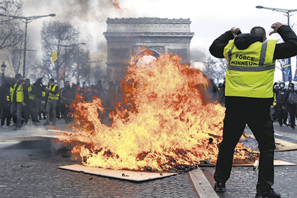 Manifestantes queman carteles frente al Arco del Triunfo en París. (Fuente: AFP)