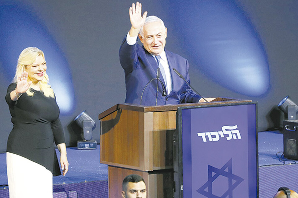 Netanyahu, junto a su esposa Sara, saluda a sus seguidores en el bunker de Likud en Tel Aviv. (Fuente: AFP)