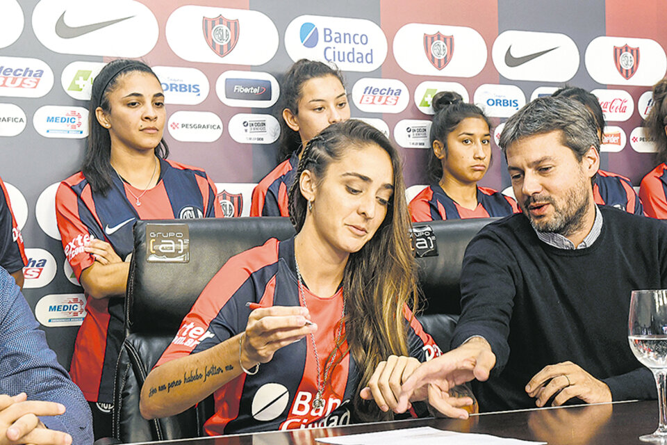 Macarena Sánchez firma su contrato junto al presidente Matías Lammens.
