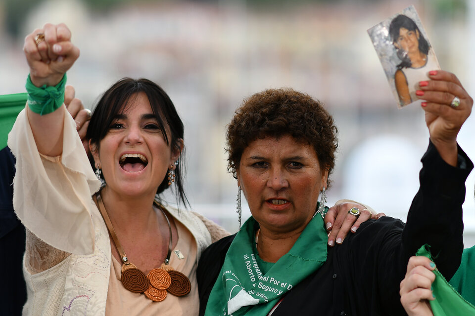 En Cannes, Norma Cuevas levanta la foto de la hija, Ana María Acevedo, junto a Cecilia Ousset.
