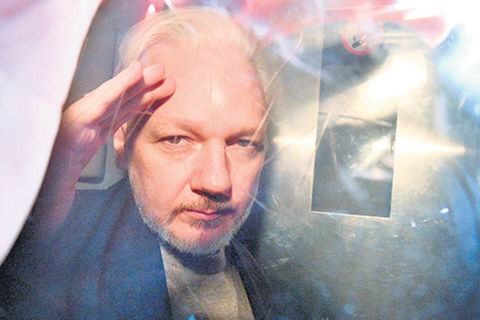 Después de la audiencia, Assange saluda desde el vehículo que lo lleva de vuelta a la cárcel. (Fuente: AFP)