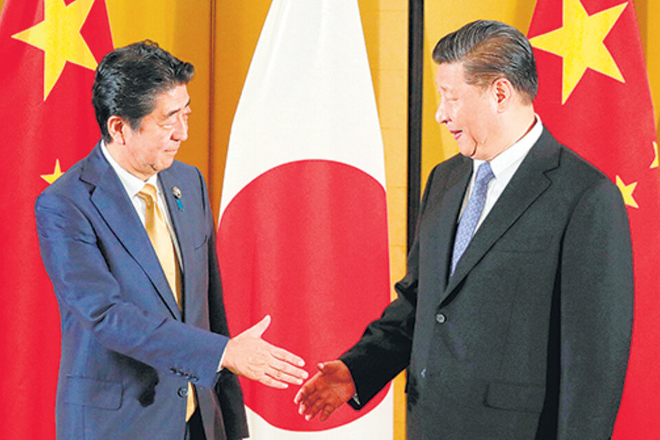 Xi Jingpin y el presidente japonés, Shinzo Abe, se dan la mano en un encuentro bilateral. (Fuente: EFE)