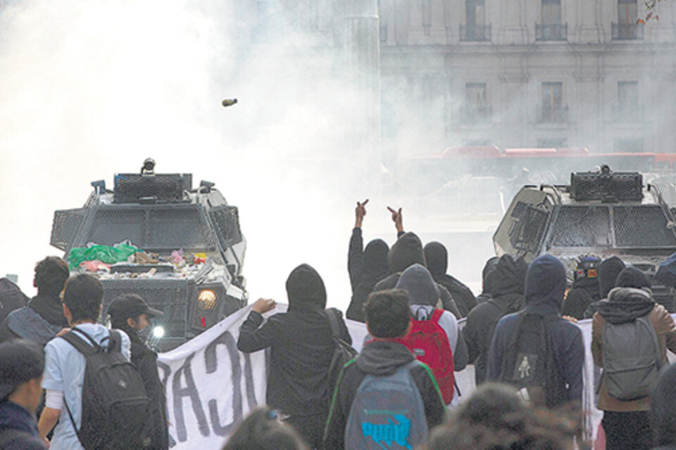 Carabineros y manifestantes se enfrentan durante la protesta docente en Santiago. (Fuente: AFP)