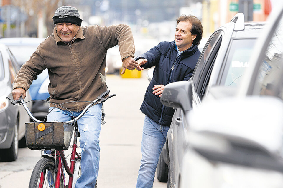 Lacalle Pou saluda a un ciclista antes de votar en Canelones.